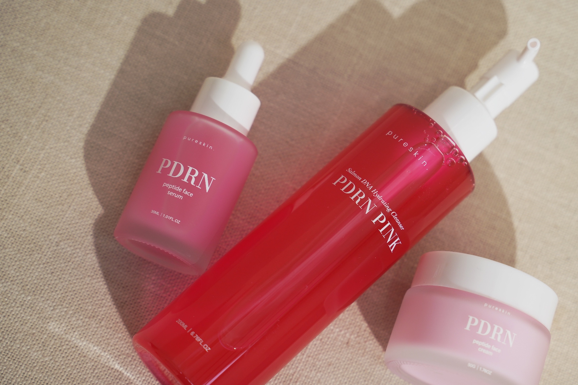 pureskin PDRN serum, hydrating cleanser and peptide cream flatlay